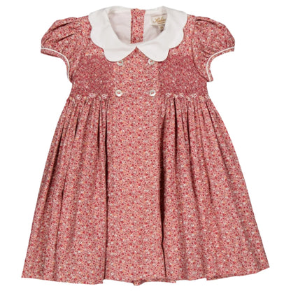 The Kidiwi Risette Smocked Dress is a red floral girls' outfit featuring short puff sleeves, a white Peter Pan collar, and front buttons, crafted from soft organic cotton.