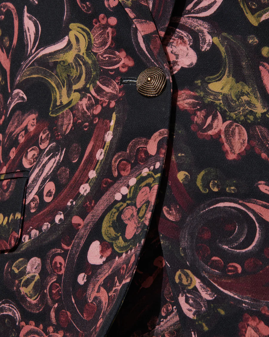 Close-up of the Figue Robin Blazer, a fall piece showcasing an abstract floral design with pink, green, and black swirls, complemented by a textured button.