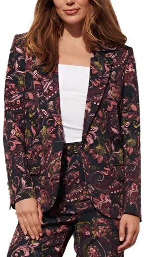 A person is striking a pose wearing a floral-patterned Figue Robin Blazer paired with a white top.