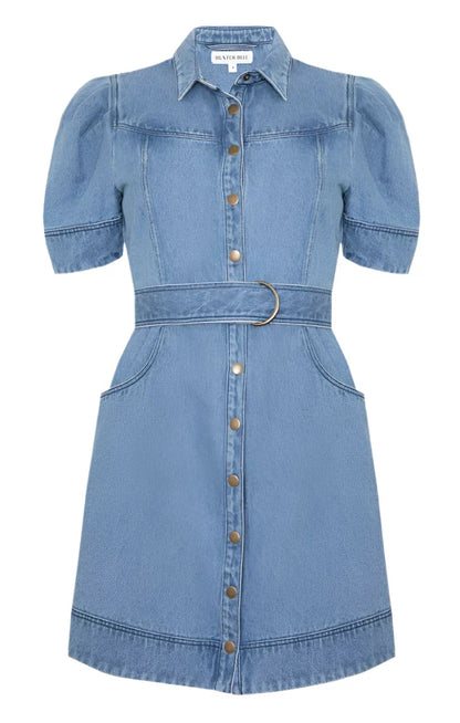 The Hunter Bell Robinson Dress from Hunter Bell NYC boasts a chic design with short sleeves, a button-down front, paneled seams, puffed sleeves, a belted waist, and convenient front pockets.