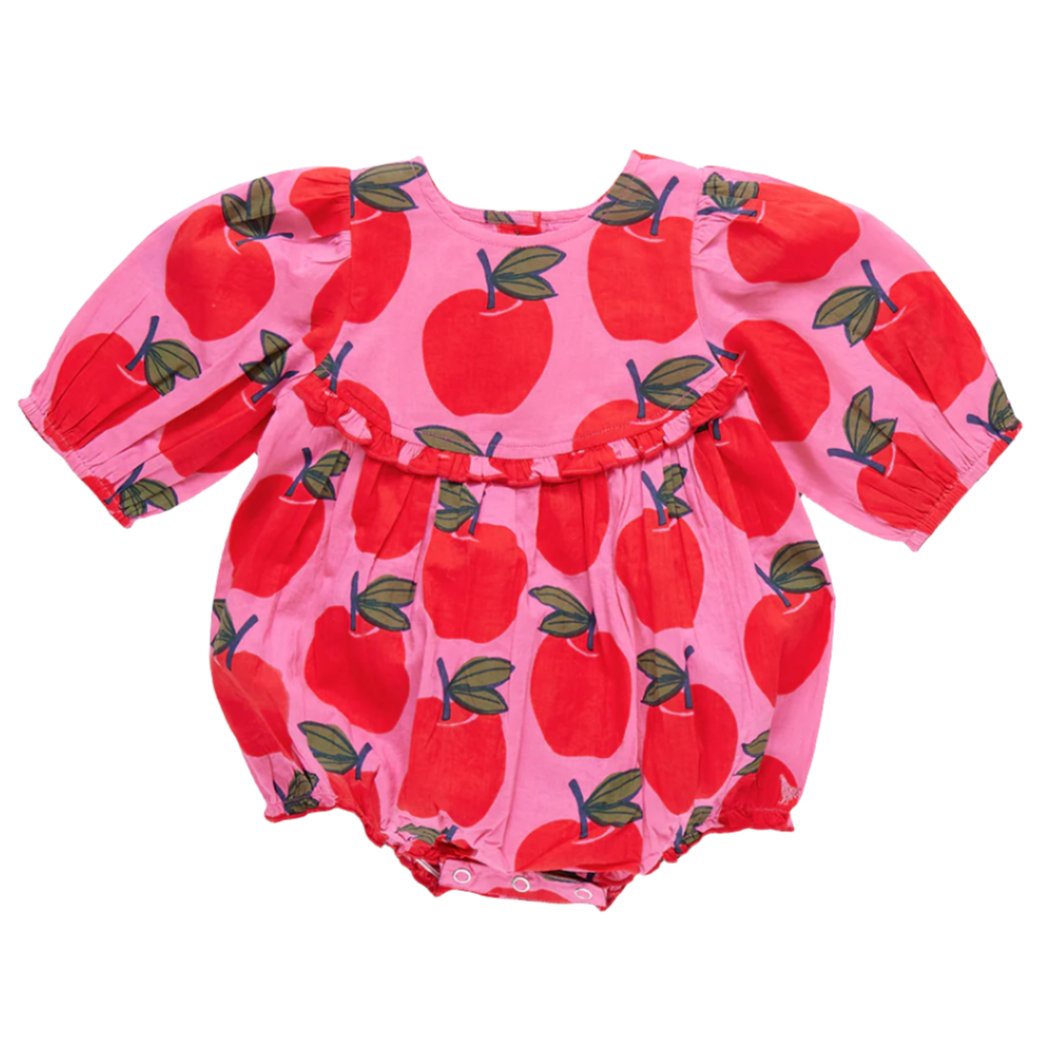 The Pink Chicken Baby Girls' Rowan Bubble romper in pink features long sleeves, graphic apples with green leaves, and glitter buttons.