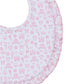 The Kissy Kissy Royal Details Bib by Kissy Kissy is a round baby bib adorned with a frilled edge. It is crafted from absorbent terry cloth and features a pink pattern of crowns, hearts, mirrors, and flowers on a white background.