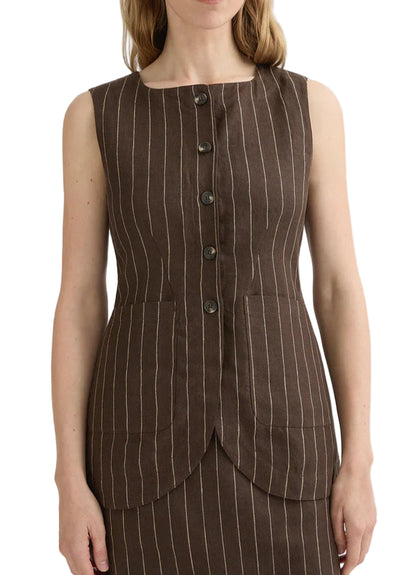 A woman wears the Emma Pinstripe Vest by POSSE—a sleeveless, brown pinstripe vest with front buttons, two large front pockets, and a classic silhouette, crafted from premium linen.
