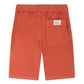The Boys' Syl Bermuda Short by Bonpoint features orange organic cotton, an elastic waistband, a back pocket with a small label, and is shown laid flat with the back side facing up.