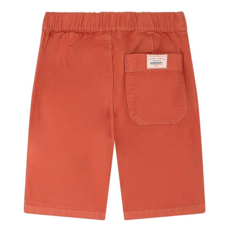 The Boys' Syl Bermuda Short by Bonpoint features orange organic cotton, an elastic waistband, a back pocket with a small label, and is shown laid flat with the back side facing up.