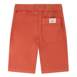 The Boys' Syl Bermuda Short by Bonpoint features orange organic cotton, an elastic waistband, a back pocket with a small label, and is shown laid flat with the back side facing up.
