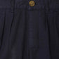 Close-up of the waistband and button closure of Bonpoint Boys' Charles Chino Bermuda Shorts with Pleats, in dark navy organic cotton, featuring pleats and belt loops.