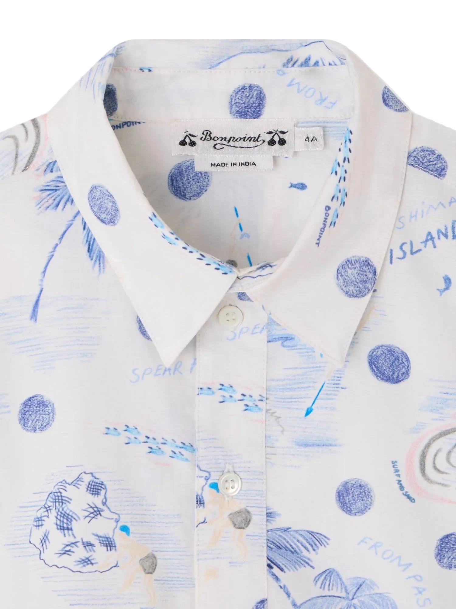 Close-up of the Boys' Erian Shirt by Bonpoint, featuring organic cotton fabric with blue island-inspired prints, white buttons, and a visible brand label inside the collar.