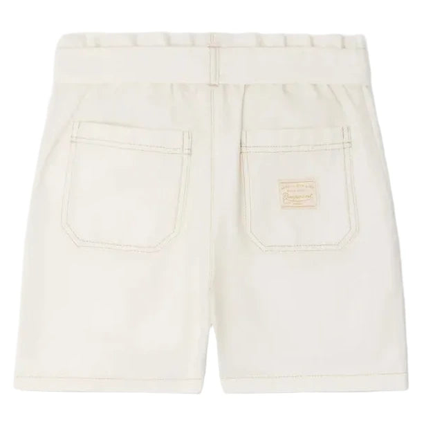Back view of Bonpoint Girls' Lorrie Shorts in beige, featuring an elastic waistband, two rear pockets, and a small rectangular patch above the right pocket.