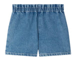 Bonpoint Girls' Milly Shorts in blue denim with an elastic waist and cherry embroidery, shown laid flat on a white background.
