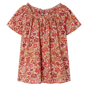The Bonpoint Girls' Goldia blouse in Liberty Fabric features short sleeves, a pink, red, and orange floral pattern, soft organic cotton material, and a gathered elasticated neckline.