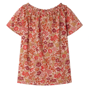 The Girls' Goldia blouse in Liberty Fabric by Bonpoint features short sleeves and a gathered neckline, decorated with a red, pink, and orange floral print on a light background.