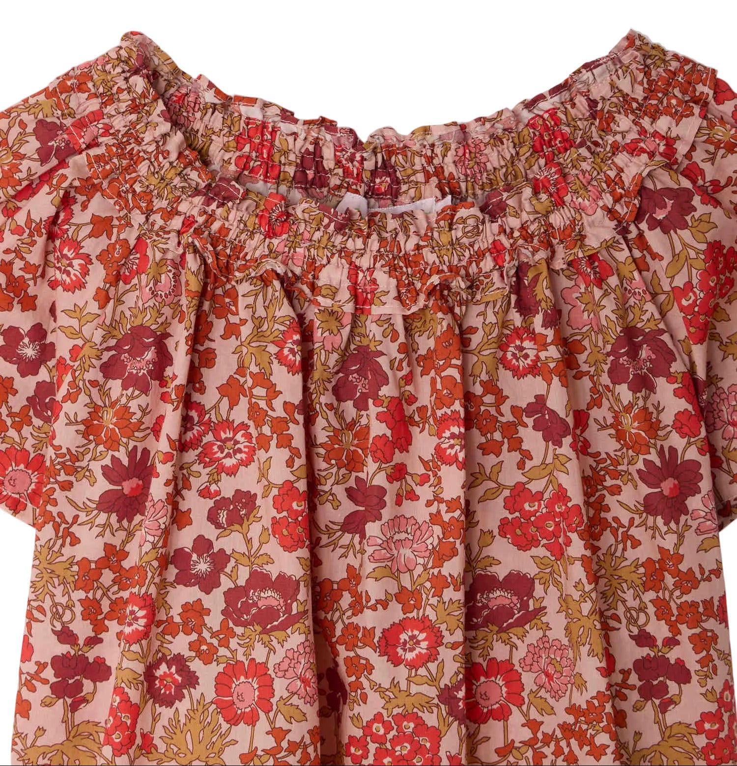 Close-up of the Bonpoint Girls' Goldia blouse in Liberty Fabric, featuring a floral print on a light pink background with a smocked off-the-shoulder neckline, crafted from soft organic cotton for comfort and style.