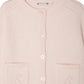 The Bonpoint Girls' Elisea Round Neck Cardigan in Organic Cotton is light pink with two front pockets, a button-down front, and openwork knit details on the shoulders and pockets.