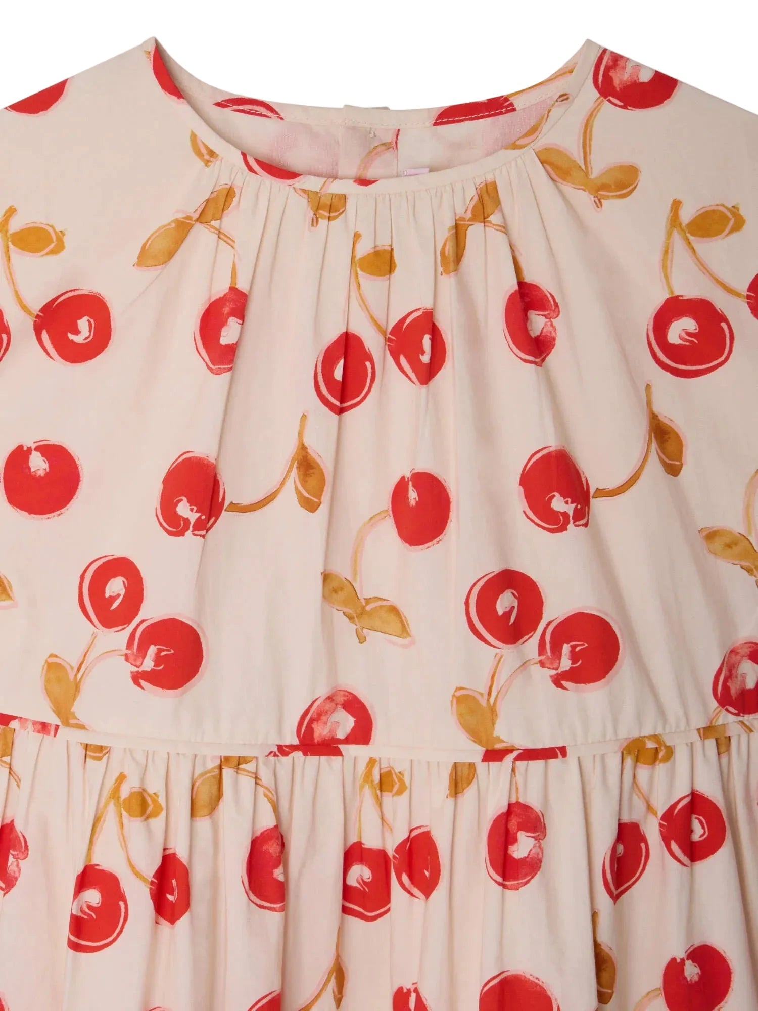 Close-up of Bonpoint's Girls' Leontine Dress with Ruffles, featuring a cream-colored organic cotton fabric adorned with vibrant red and yellow cherry prints and a gathered neckline.