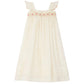 The Bonpoint Girls' Laora Dress Smocked and Hand-Embroidered is a sleeveless cream dress with ruffled straps and a pink and yellow hand-embroidered smocking band across the chest.