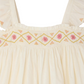 The Bonpoint Girls' Laora Dress Smocked and Hand-Embroidered features cream fabric, ruffled sleeves, and pink and yellow diamond hand embroidery—an elegant choice for special occasions.