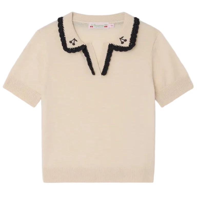The Bonpoint Girls' Lisette Sweater features short sleeves, a cream knit, a scalloped black-trimmed notched lapel collar, and delicate hand-embroidered cherries near the neckline.