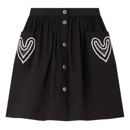 The Bonpoint Girls' Lierre Hand-Embroidered Skirt is black with front buttons and two large front pockets, each adorned with delicate white hand-embroidered hearts.