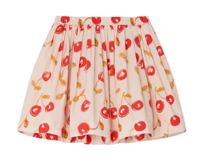 The Girls' Suzon Skirt by Bonpoint is a short, pleated skirt made from organic cotton with a white base, decorated with red cherry prints and yellow-brown stems and leaves.