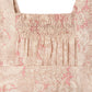 Close-up of Bonpoint's Baby Girls' Lakiss Romper, smocked and hand-embroidered in Liberty fabric, featuring a square neckline and pink floral print.