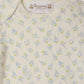 Close-up of the Baby Timi Set with Sailboat Print by Bonpoint, a cream-colored organic cotton onesie featuring a charming sailboat pattern with green dots and a Bonpoint label at the neckline.