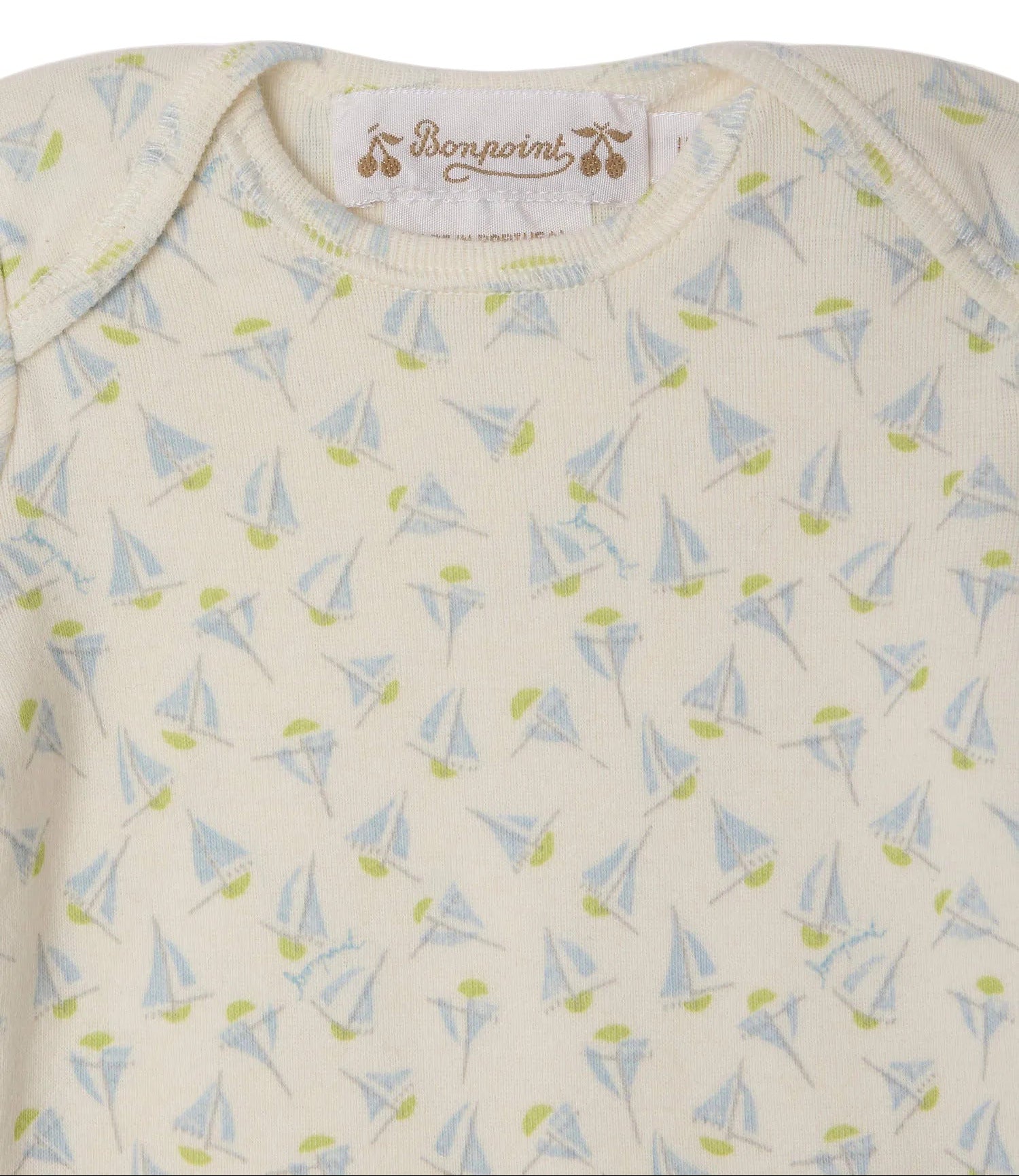 Close-up of the Baby Timi Set with Sailboat Print by Bonpoint, a cream-colored organic cotton onesie featuring a charming sailboat pattern with green dots and a Bonpoint label at the neckline.