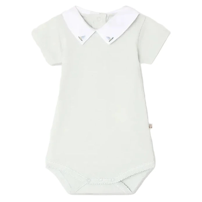 Bonpoint’s Baby Juillet Bodysuit features hand-embroidered sailboats, soft organic cotton, short sleeves, a white Peter Pan collar, and two buttons at the back of the neck.