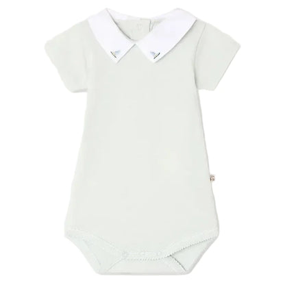 Bonpoint’s Baby Juillet Bodysuit features hand-embroidered sailboats, soft organic cotton, short sleeves, a white Peter Pan collar, and two buttons at the back of the neck.