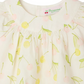 Close-up of the Bonpoint Baby Girls' and Girls' Lala Blouse in white organic cotton, with a yellow and pale pink cherry print, gathered neckline, mother-of-pearl buttons, and "Bonpoint" label inside the collar.