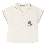 The Bonpoint Baby Boys' and Boys' Lennard Shirt is a short-sleeved cream shirt in organic cotton, with dark stitching on the collar and sleeves, button front, and a chest pocket embroidered with palm trees.
