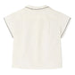 Back view of Bonpoint's Baby Boys' and Boys' Lennard Shirt, an off-white, short-sleeve organic cotton shirt featuring dark stitched details on the collar and sleeve edges.
