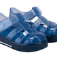 The Girls' Star Jelly Sandal by Igor features blue translucent PVC, closed toes, Velcro straps, a removable footbed, and thick black soles.