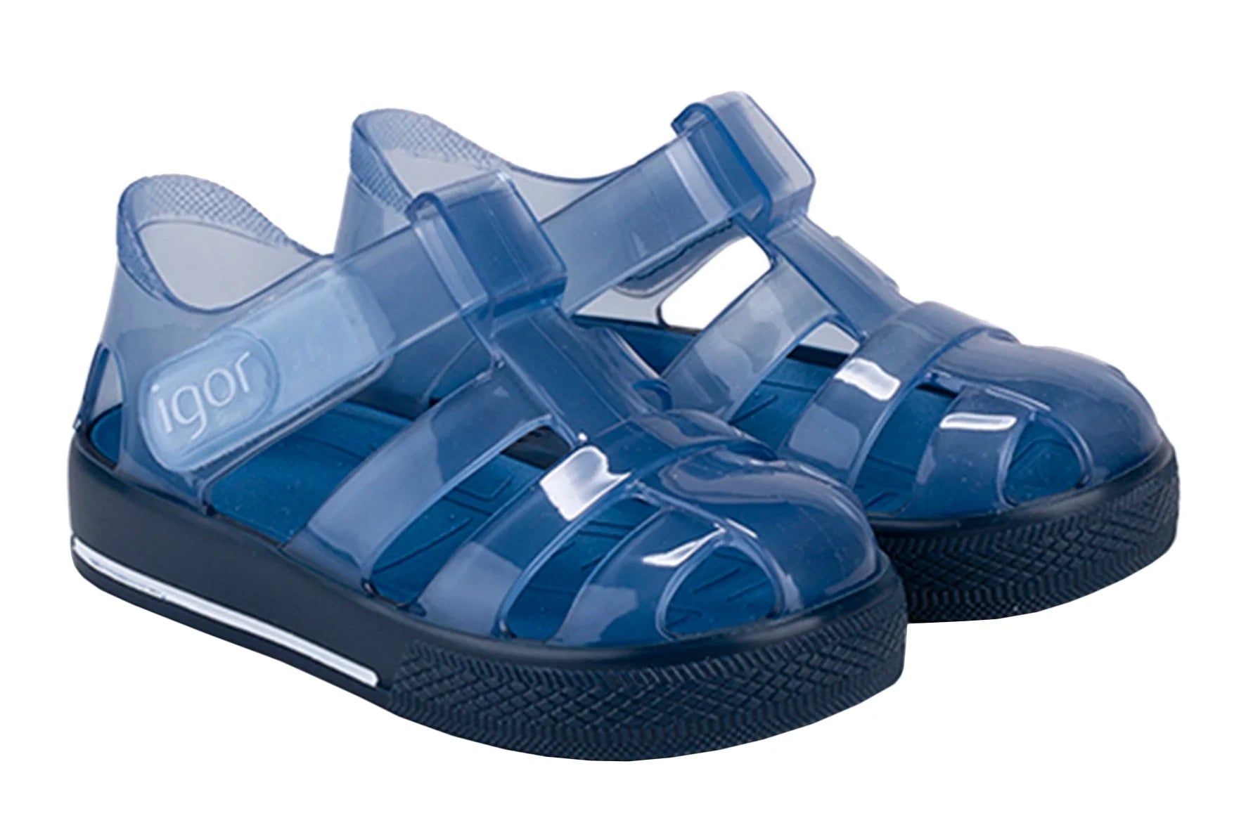 The Girls' Star Jelly Sandal by Igor features blue translucent PVC, closed toes, Velcro straps, a removable footbed, and thick black soles.