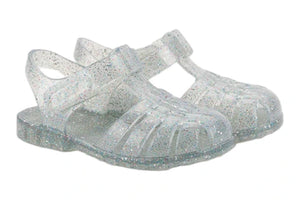 The Igor Clasica Cristal Sandal is a pair of translucent jelly shoes with glitter, Scandi-inspired colors, closed toes, flexible soles, and ankle straps.