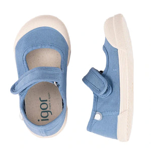 The Igor Kids' Lona Canvas Sneaker is a blue cotton canvas toddler shoe with white rubber soles, velcro straps, and rounded toes in a barefoot sneaker style, shown from top and side views.
