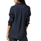 A woman is shown from the back against a white background, wearing the Ann Mashburn Icon Silk Blouse in navy blue with long sleeves, paired with dark pants.