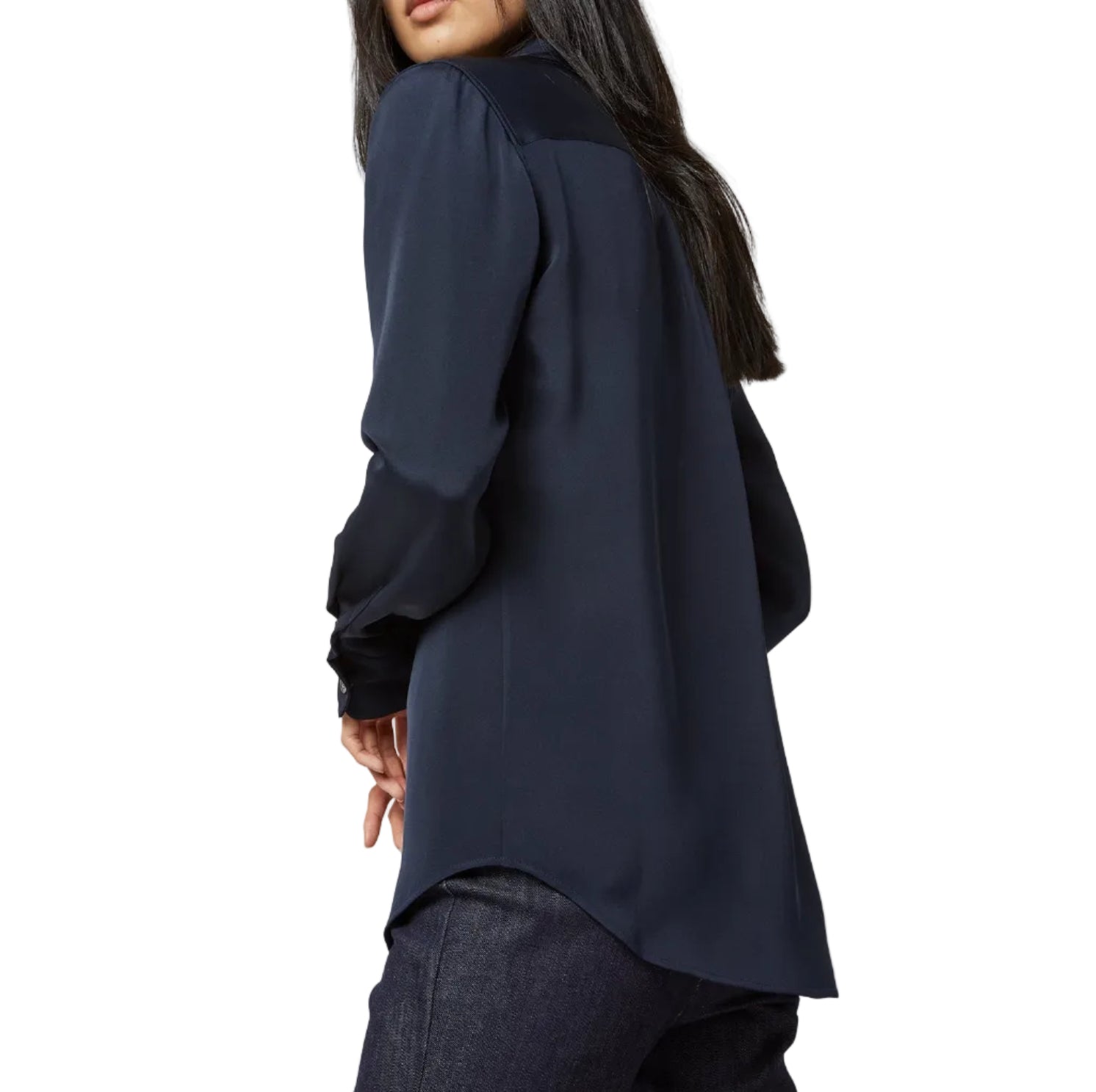 A woman is seen from the back wearing Ann Mashburn’s Icon Silk Blouse in dark navy with dark pants, standing against a white background.