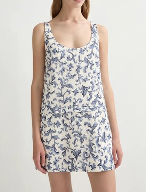 A woman wears the POSSE Rue Shift Dress, a vintage floral sleeveless dress with a blue pattern, standing against a plain light background.