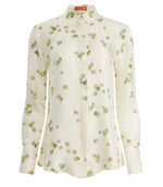 The Chika Top by Altuzarra is a cream silk, long-sleeve button-down with green and yellow floral print, pointed collar, and cuffed sleeves for a relaxed look.
