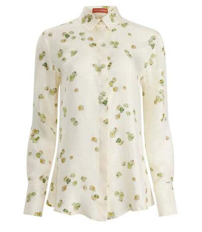 The Chika Top by Altuzarra is a cream silk, long-sleeve button-down with green and yellow floral print, pointed collar, and cuffed sleeves for a relaxed look.