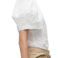 Side view of a person wearing a 3.1 Phillip Lim Bloom Sleeve Scoop Neck Top shirt and beige trousers.