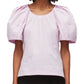 Woman wearing a pink 3.1 Phillip Lim Bloom Sleeve Scoop Neck Top with puff sleeves.