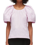 Woman wearing a pink 3.1 Phillip Lim Bloom Sleeve Scoop Neck Top with puff sleeves.