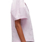 Side view of a person wearing a 3.1 Phillip Lim Bloom Sleeve Scoop Neck Top, crafted from cotton polyester blend, in light pink.