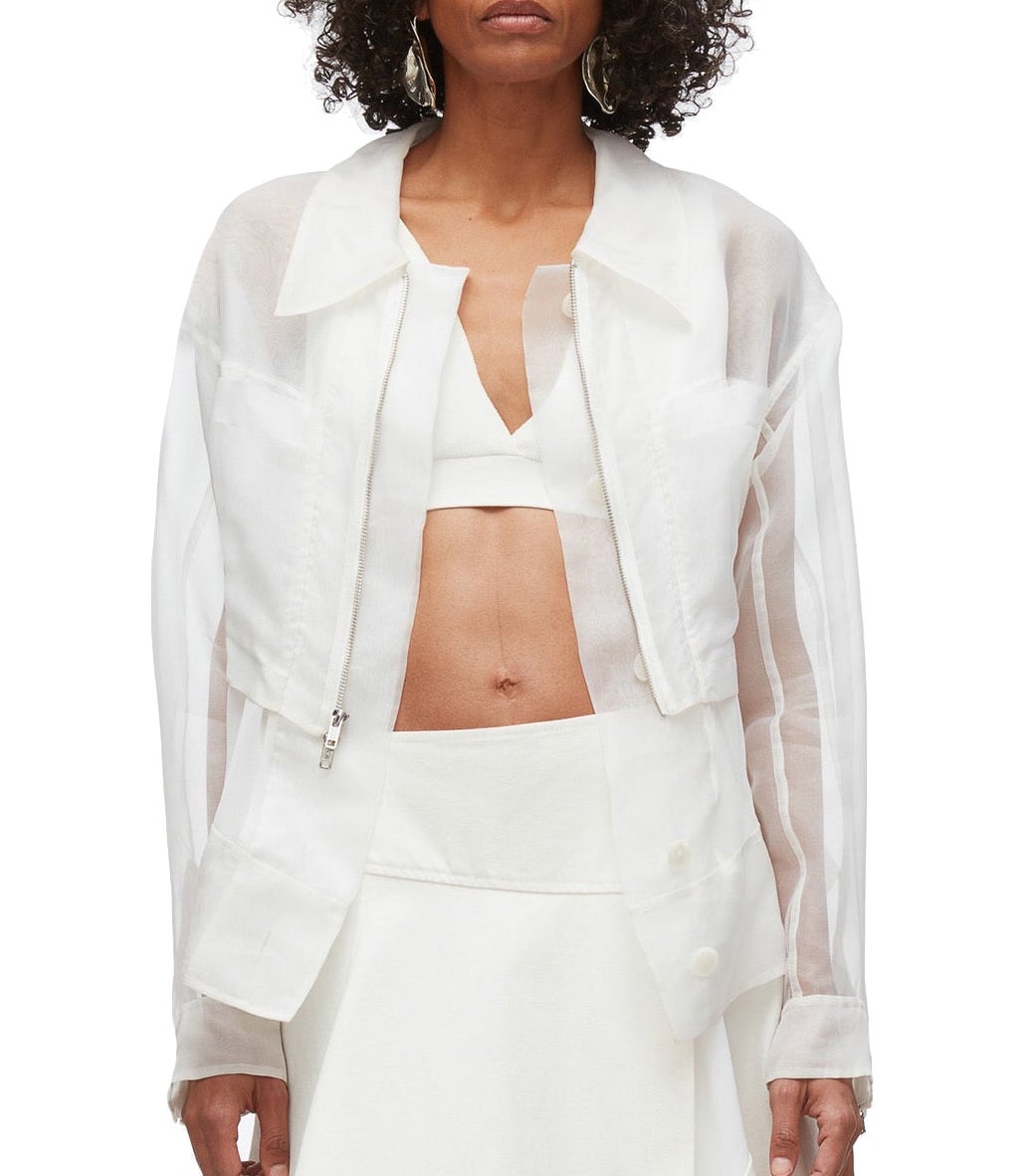 A person wearing a 3.1 Phillip Lim Organza Belted Flounce Jacket over a white crop top and skirt stands against a plain background, effortlessly embodying smart casual style.