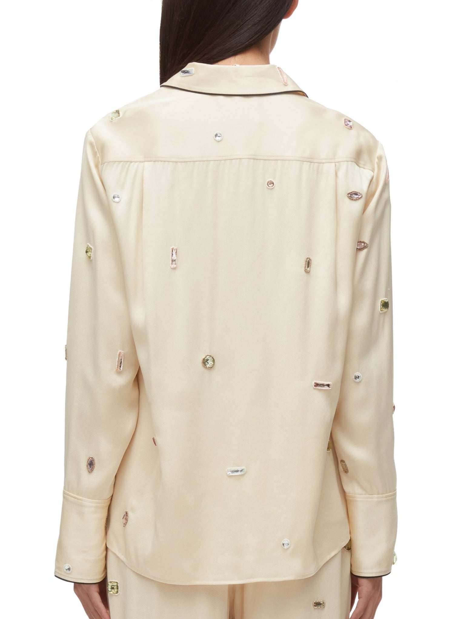 A person wearing a 3.1 Phillip Lim Halo Embroidered PJ Shirt with various small embellishments on the back, exuding a touch of New York glamour. The individual is shown from behind, and the shirt has a collar and long sleeves.