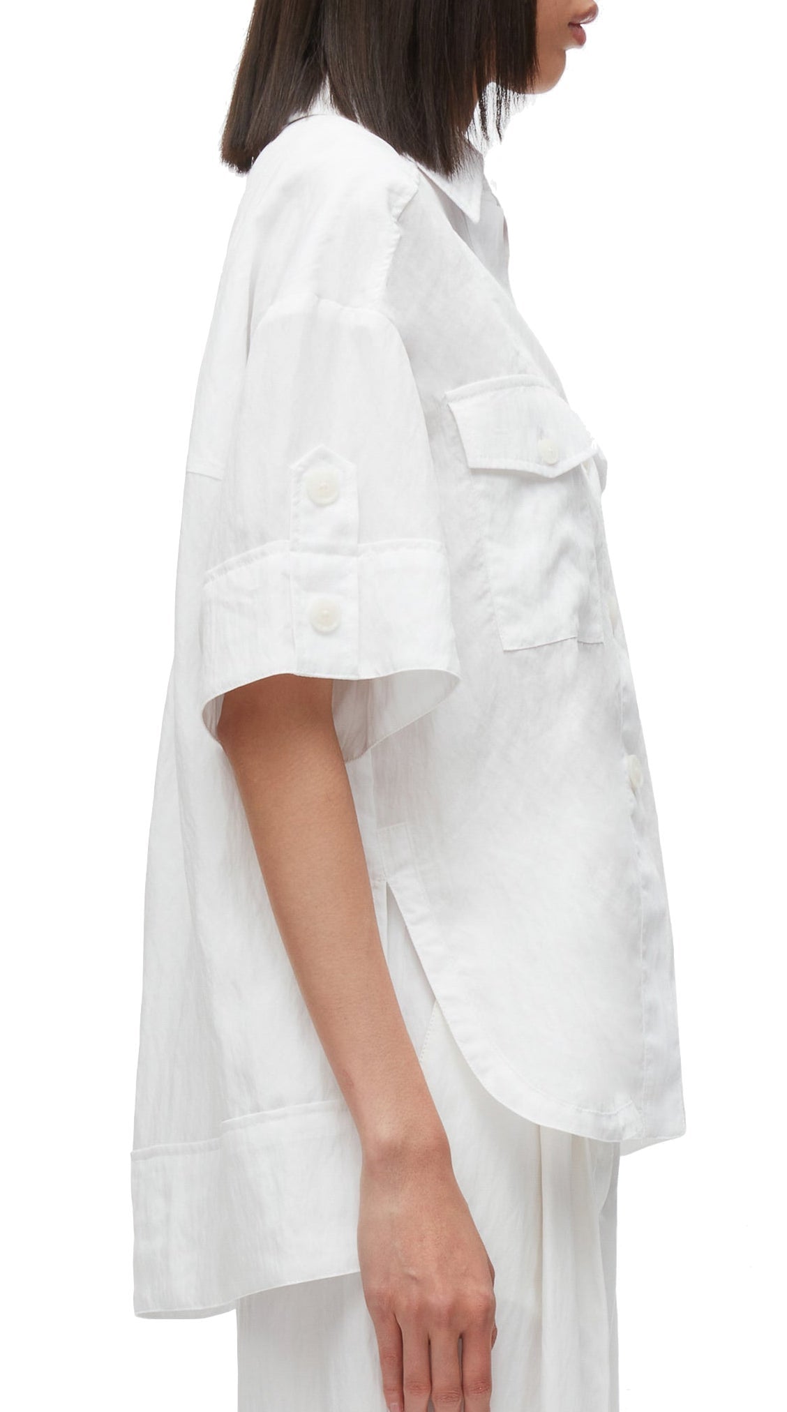 Woman wearing a white 3.1 Phillip Lim Oversized Camp Shirt with a focus on the side cargo pocket construction and sleeve details.