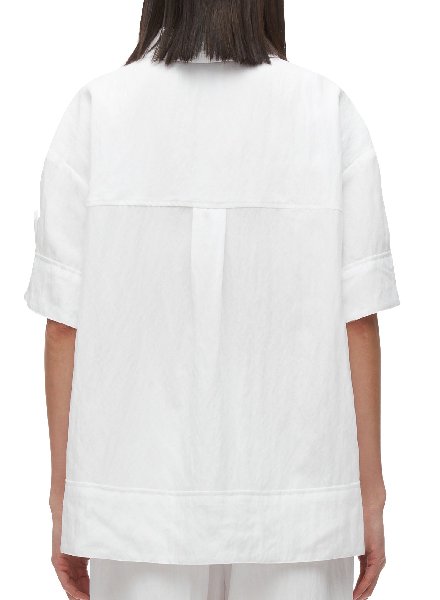 Rear view of a person wearing a 3.1 Phillip Lim Oversized Camp Shirt in plain white, with a center back pleat detail.