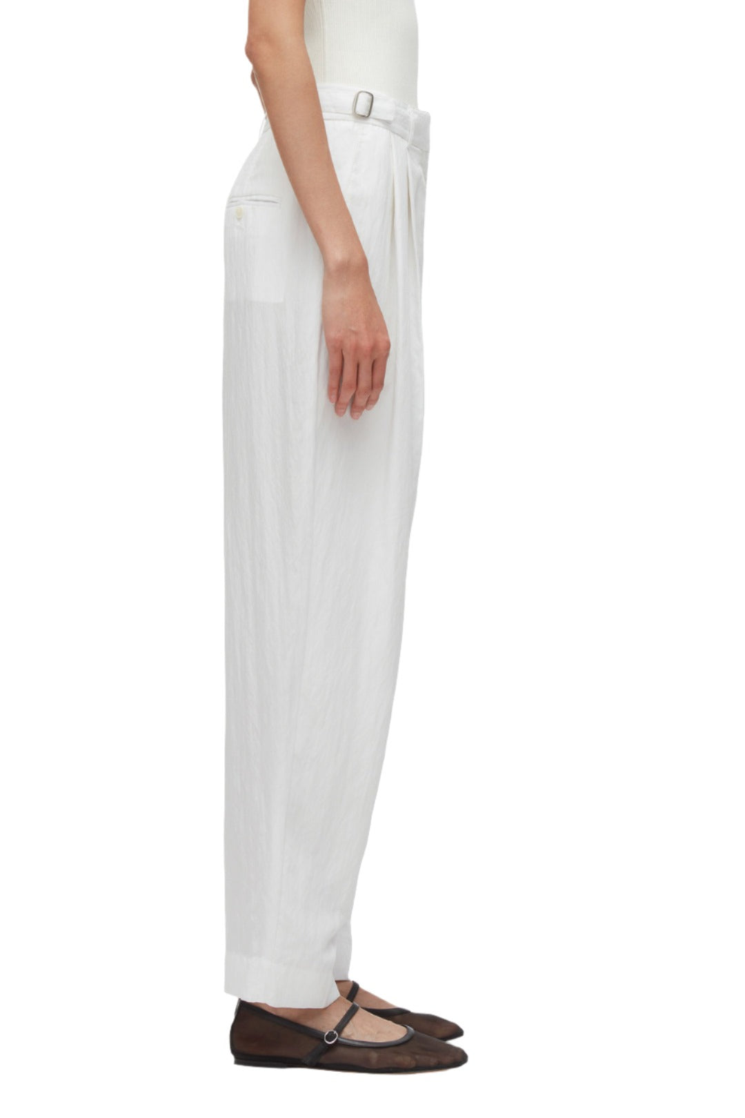 A person in a white top and the 3.1 Phillip Lim Double Pleated Tapered Trousers made of soft poplin stands in profile, wearing brown Mary Jane flats.